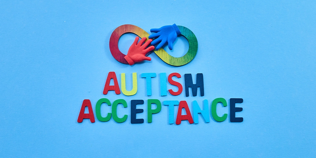 Two hands reaching out to each other against a plain background, symbolizing connection and support for individuals with autism.