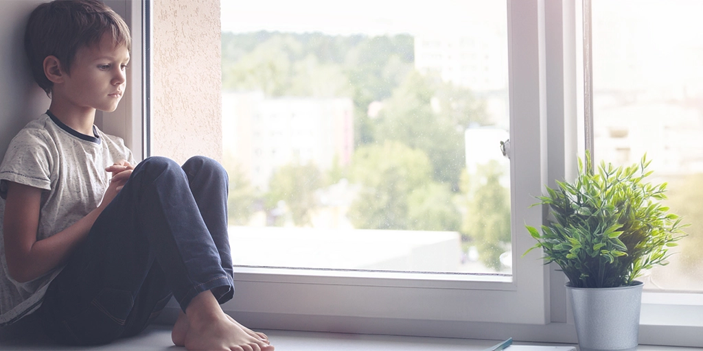 This image of a young boy represents the introspective and solitary moments often experienced by individuals with autism, highlighting the need for understanding and support across all levels of the spectrum.